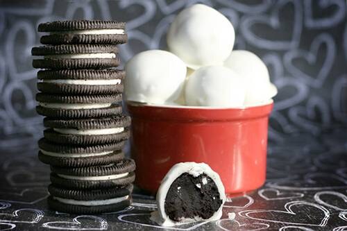 Picture of a stack of regular Oreo Cookies, plus a bowl full of the finished treats, including one that is missing a bite (which shows the inside).